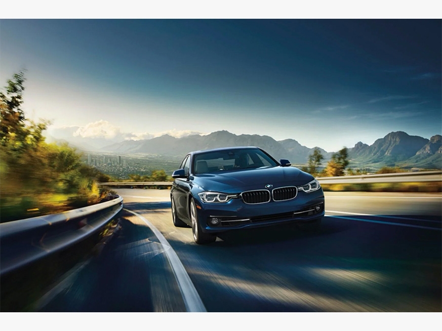 BMW 3 Series driving with mountainous background