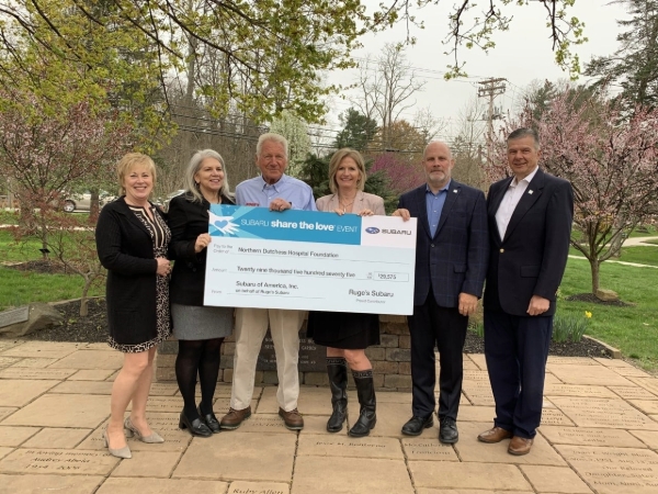 A group of people holding a giant check.