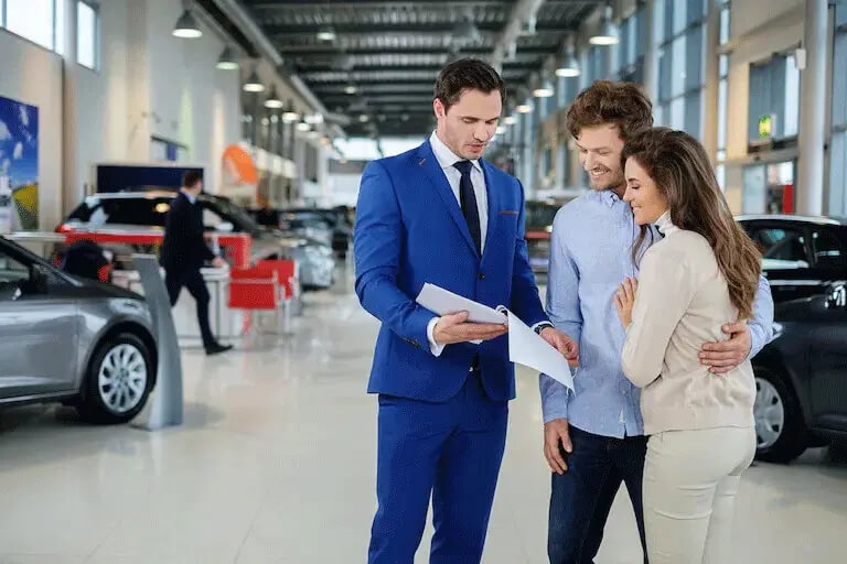 Car salesman assisting customers inside Great Lakes Honda dealership showroom
