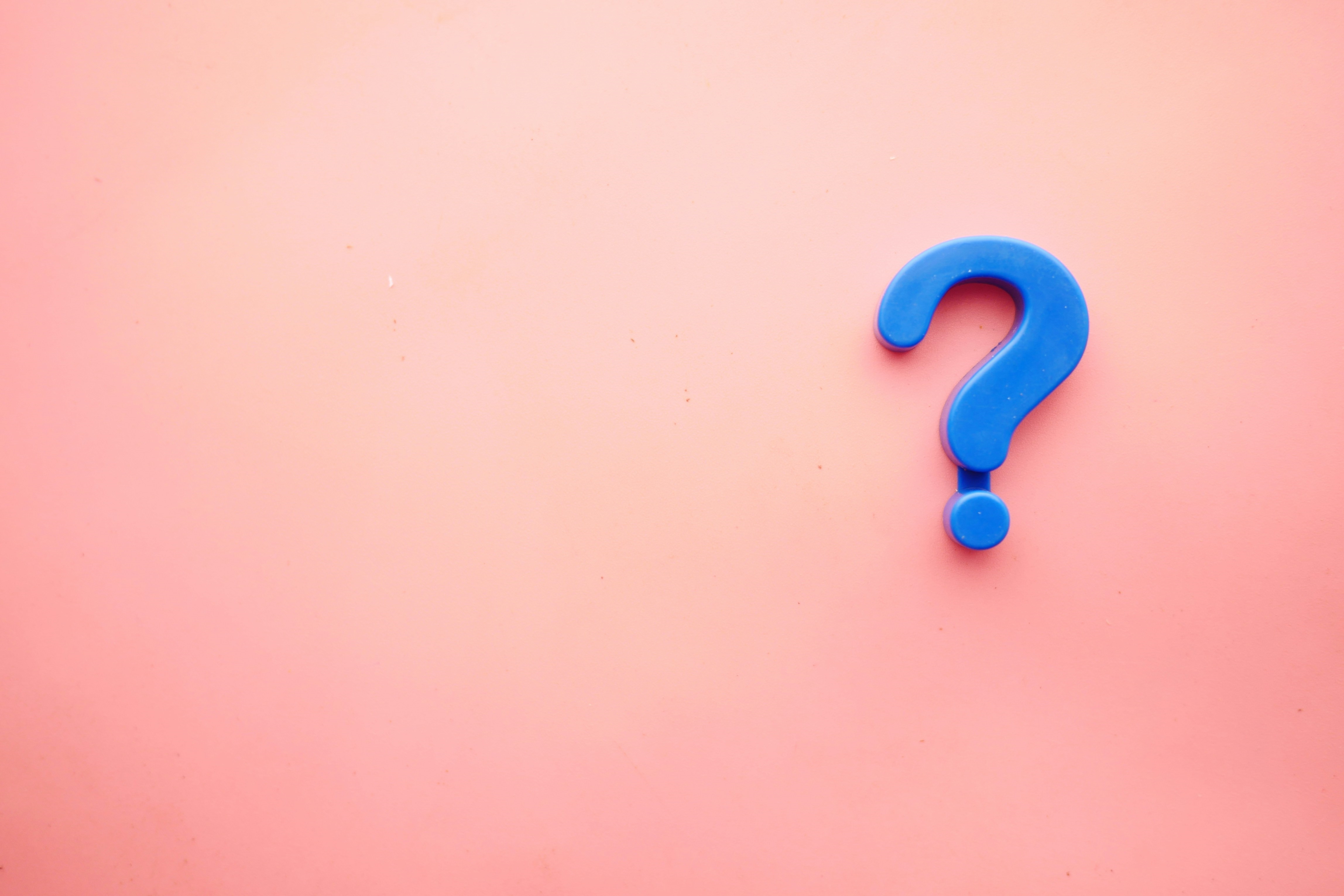 Blue question mark against coral background