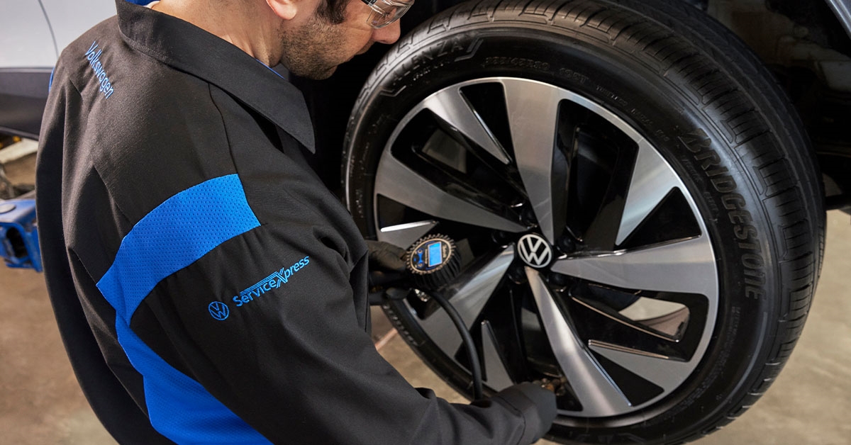 VW technician working on tire