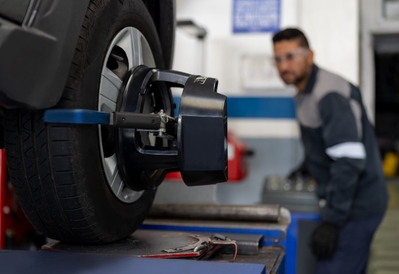 Wheel alignment service in progress using an alignment machine on a car tire in Akron, OH