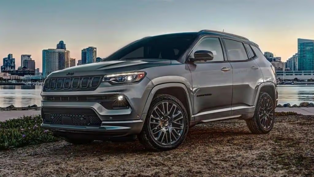 exterior view of a 2022 dark gray jeep compass with a city skyline in the background