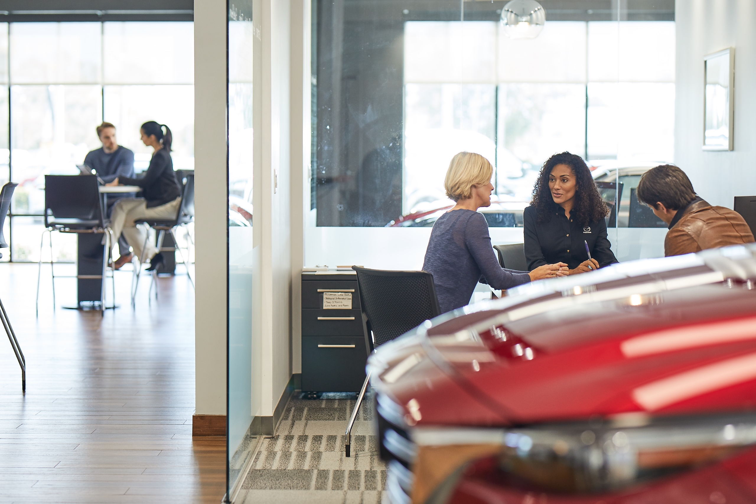 Mazda dealer and customers in showroom