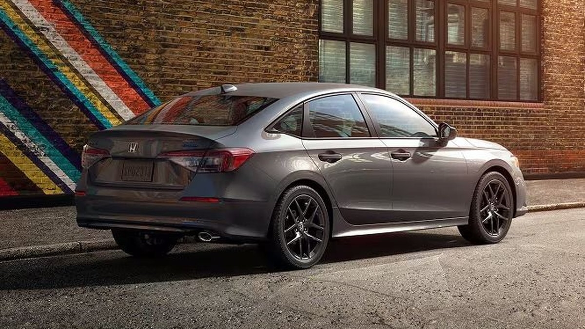 2026 Honda Civic Sport sedan in gray parked against a brick wall with a mural