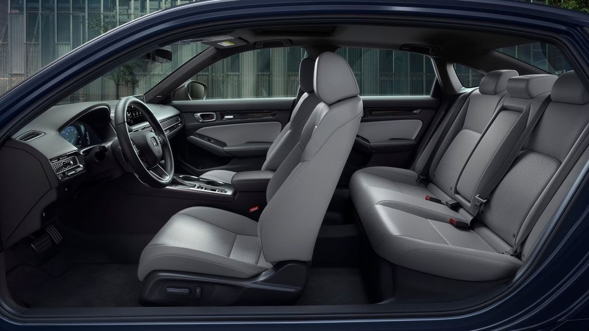 2026 Honda Civic Sport Touring Hybrid leather front and rear seats viewed through the open driver door