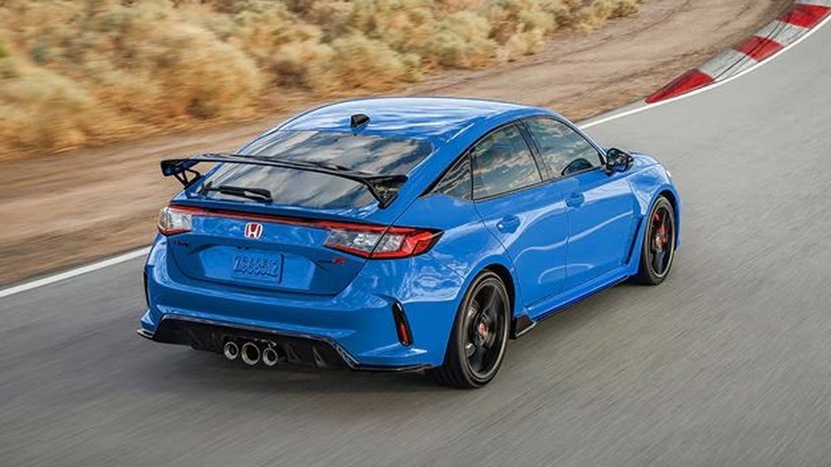 2026 Honda Civic Type R in blue cornering hard on a race track with a visible rear wing