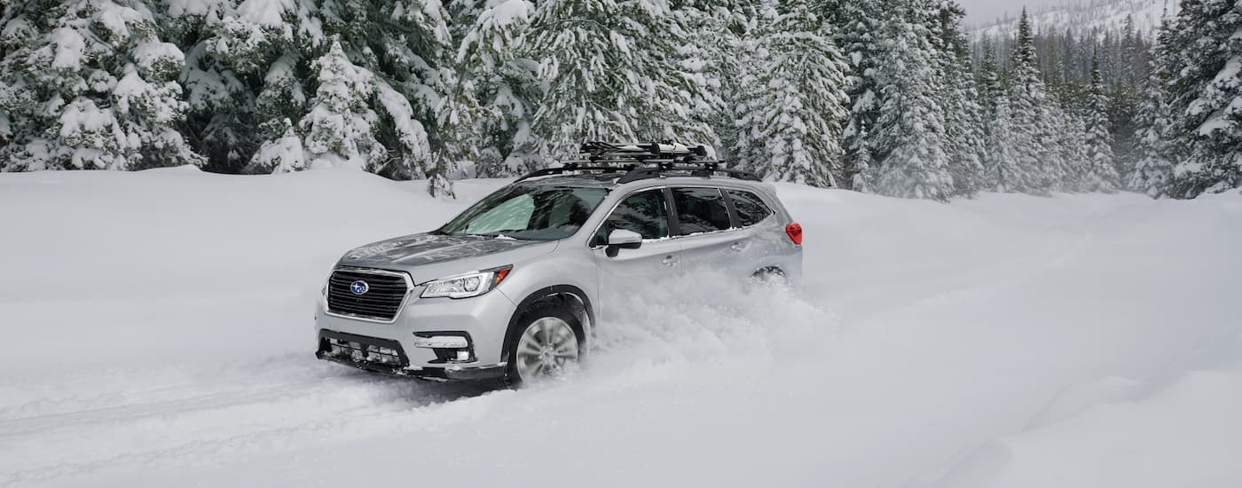 A silver 2020 Subaru Ascent Limited is shown driving through the snow after visiting a Subaru dealer near you.