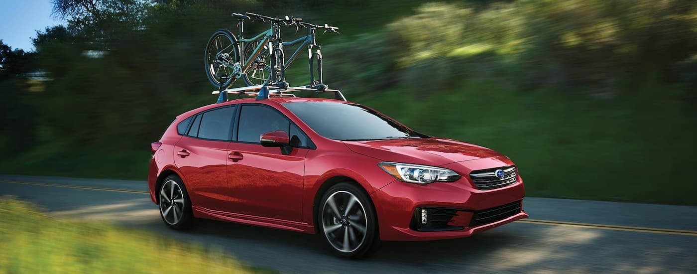 A red 2022 Subaru Impreza Sport is shown with bikes on the roof.