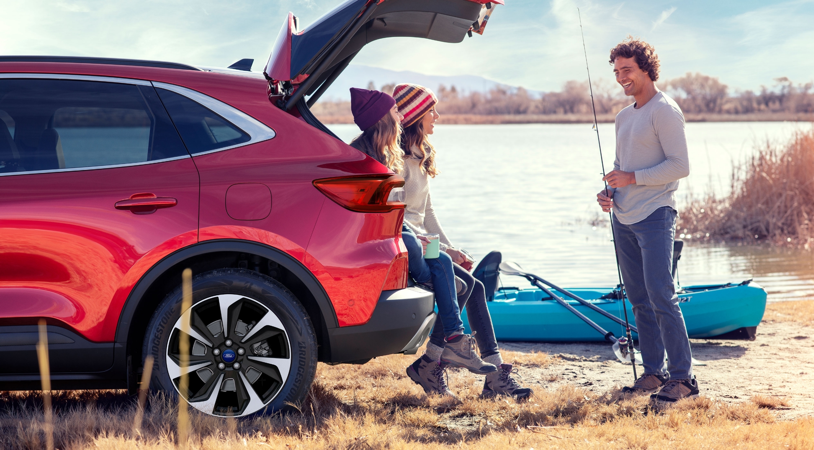  Friends enjoying the outdoors fishing and kayaking 2 female friends sitting on the rear of a new 2023 Ford SUV