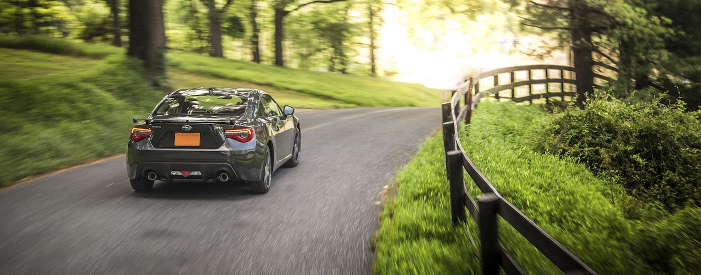 A grey 2019 Subaru BRZ Limited is shown driving past a fence.