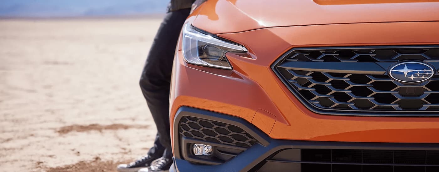 A close up of the grille on an orange 2022 Subaru WRX Limited is shown in a desert.