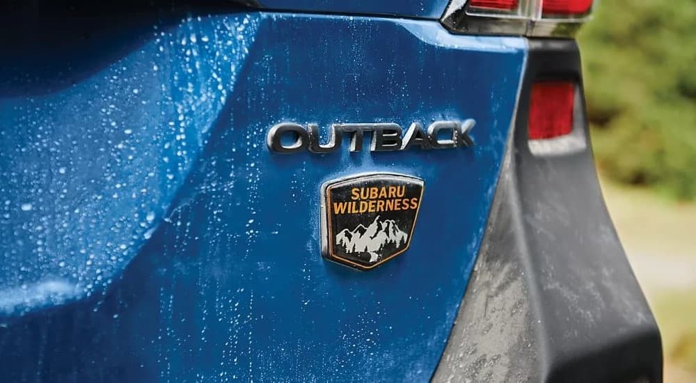 A close up shows the badge on a dark blue 2023 Subaru Outback for sale.