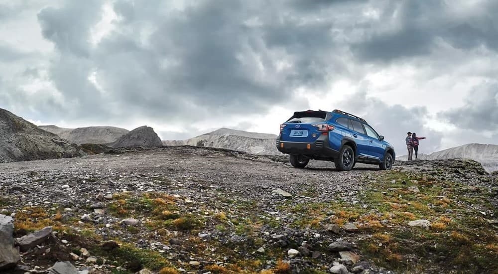 A dark blue 2023 Subaru Outback Wilderness is shown on a cloudy day.