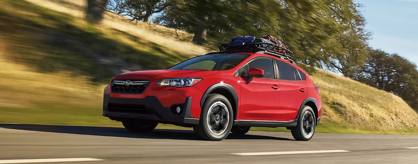 A red 2023 Subaru Crosstrek Premium for sale is shown driving on an open road.