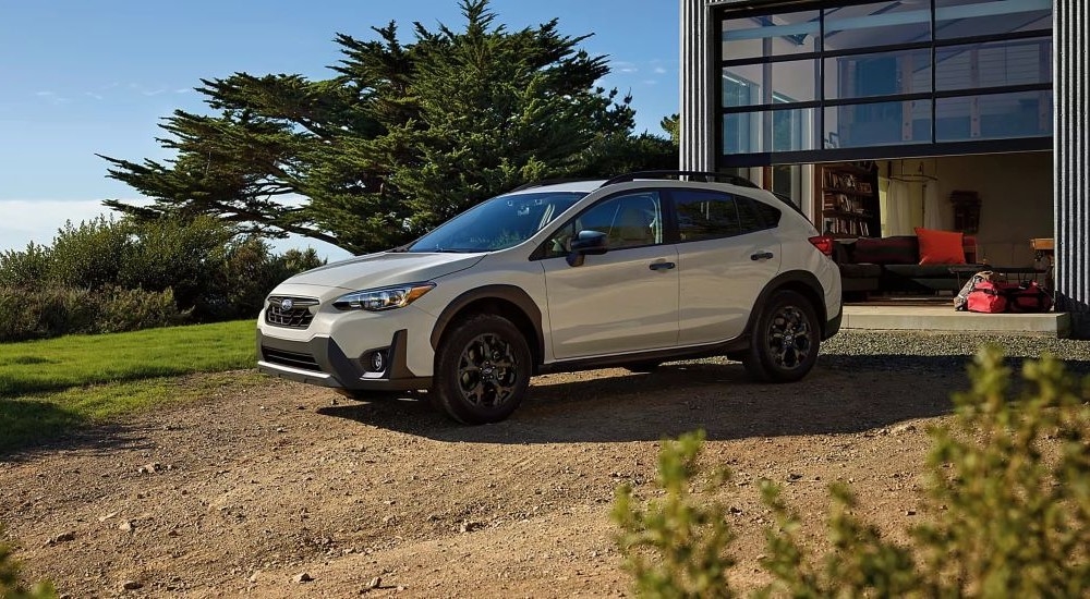 A grey 2023 Subaru Crosstrek for sale is shown parked on a driveway.