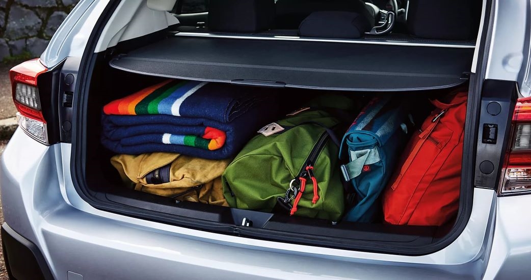 A close up shows luggage in the trunk of a silver 2023 Subaru Crosstrek for sale.