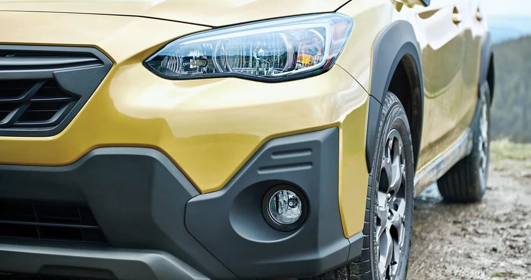A close up shows the drive side headlight on a yellow 2023 Subaru Crosstrek Sport.