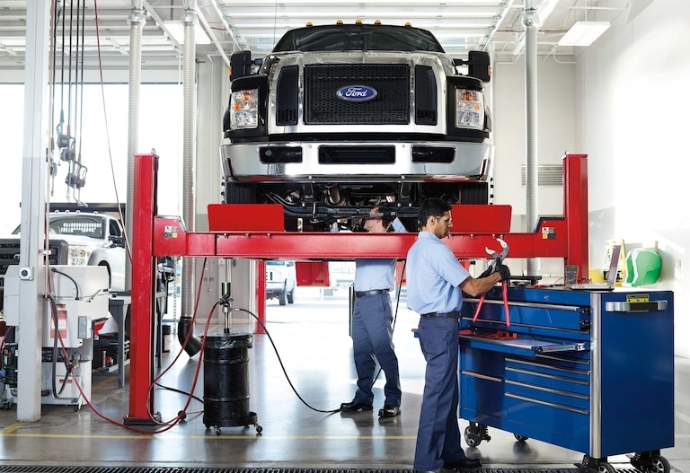 Two Technicians at Landmark Fords Body Shop fixing and repairing a lifted Ford truck