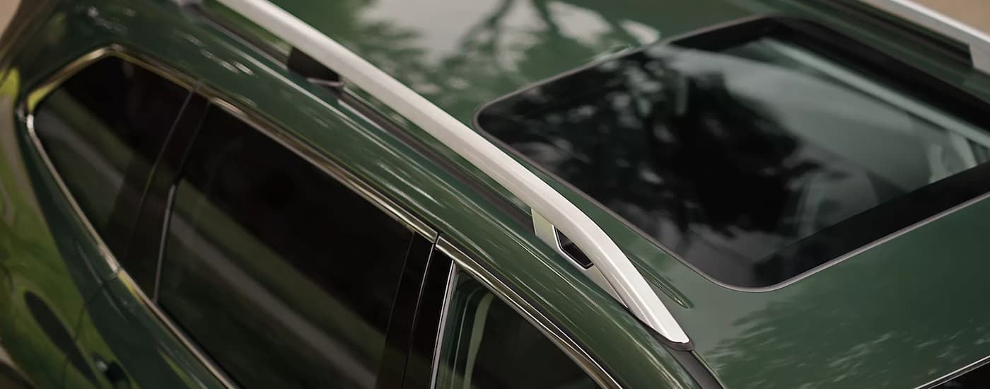 A close-up of the roof and sunroof on a green 2023 Subaru Forester.
