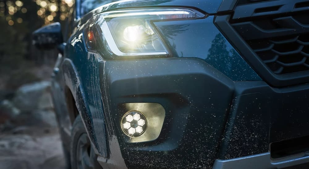 A close up of the front of a blue 2023 Subaru Forester Wilderness shows the headlight.