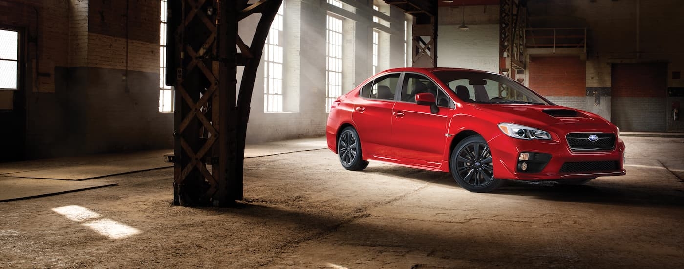 A red 2017 Subaru WRX is shown parked in a warehouse.