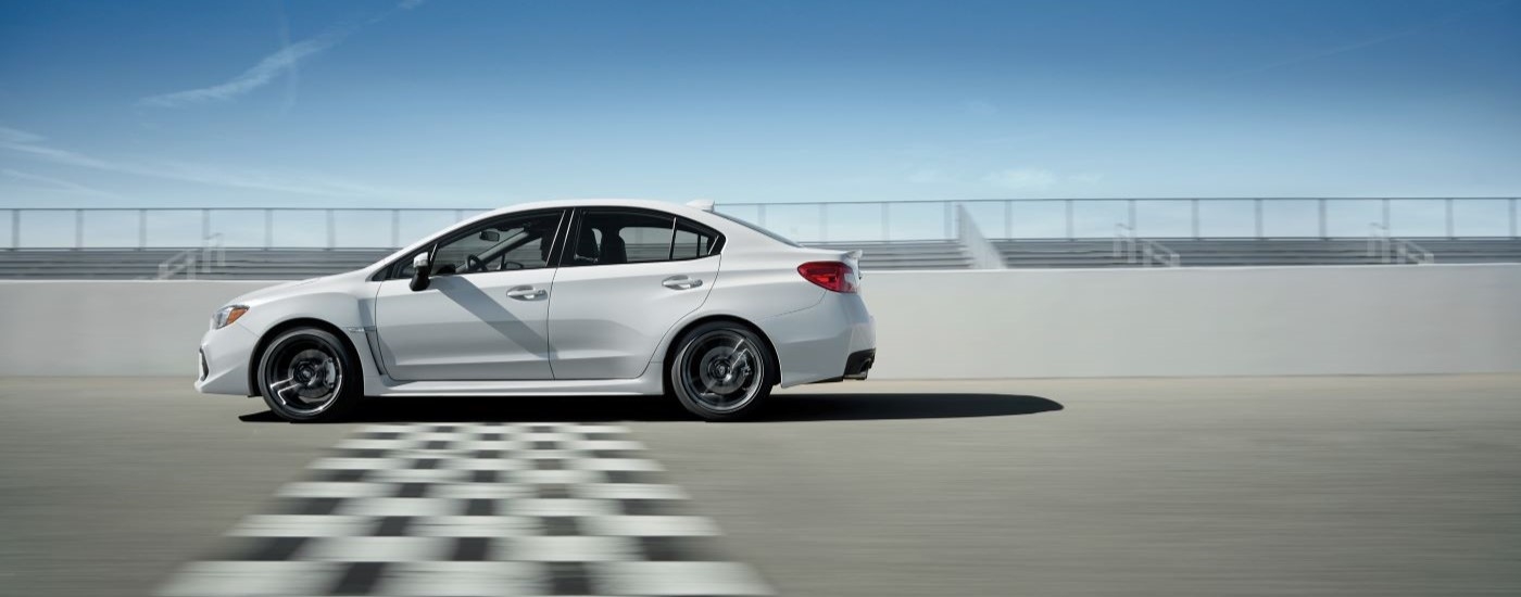 A white 2019 Subaru WRX for sale is shown from the side crossing a finish line.