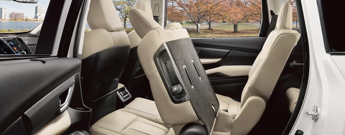 The tan interior of a 2023 Subaru Ascent for sale shows the second row of seating tilted.