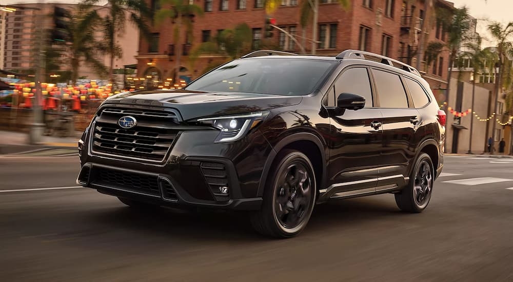 A black 2023 Subaru Ascent Onyx Edition is shown driving on a city street.