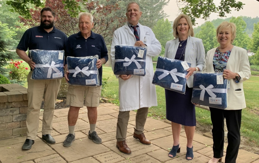 A group of Ruge's Subaru and hospital employees holding gifts.