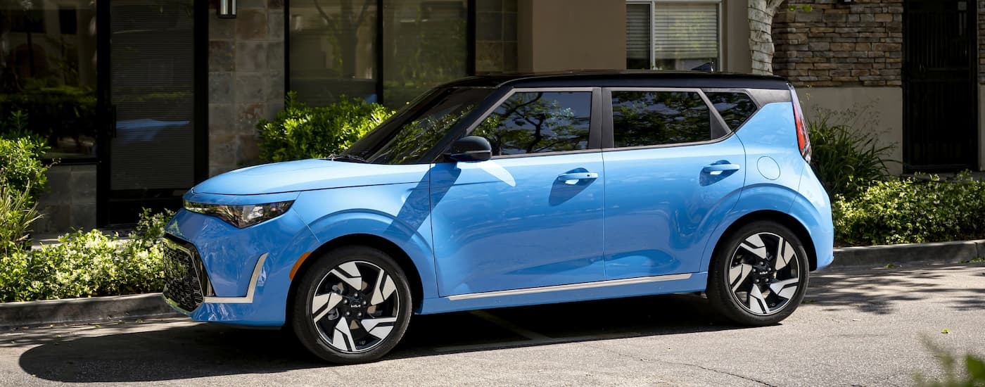 A blue 2023 Kia Soul parked on the side of a street afre leaving a Kia dealership.