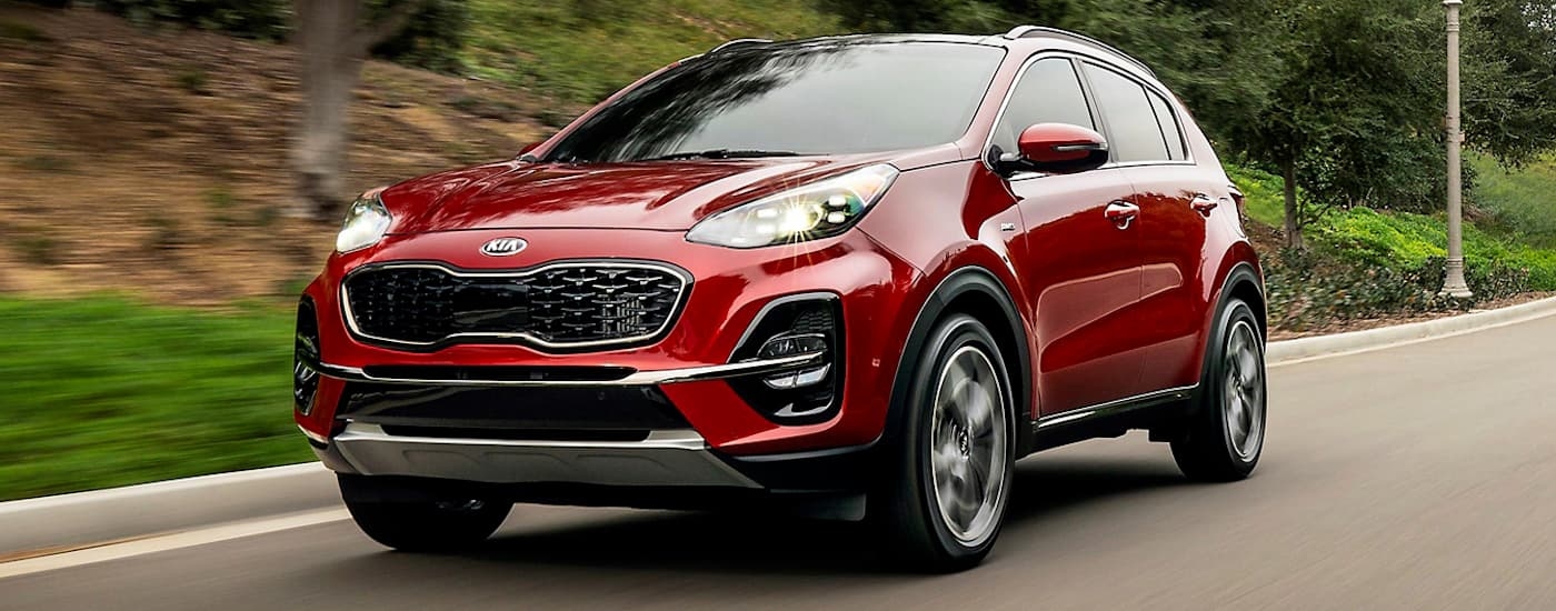 A red 2020 Kia Sportage is shown driving on an open road after leaving a used Kia dealer near Port Lavaca.