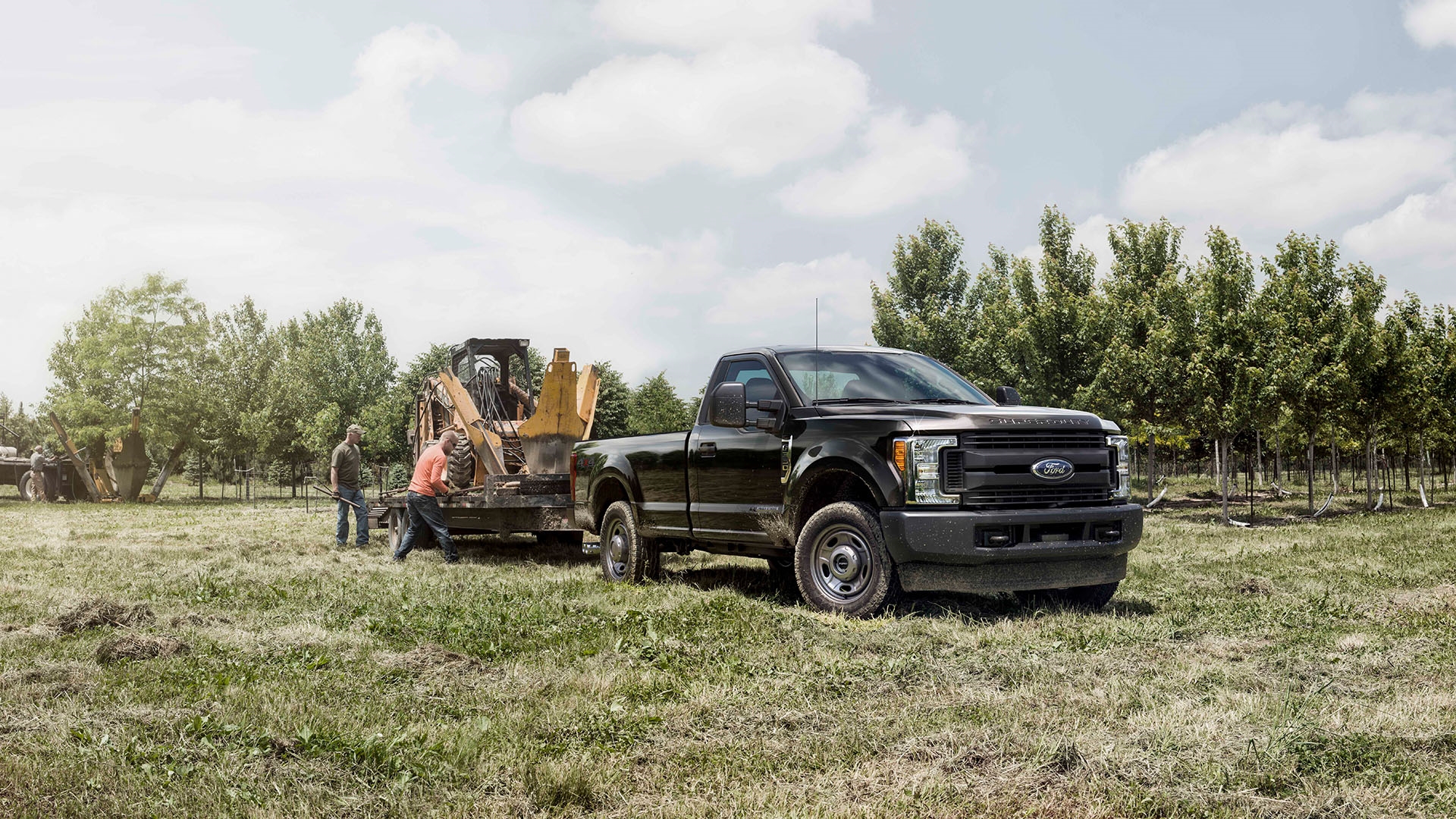 ford f-150 rural setting workers adding machine to tow behind