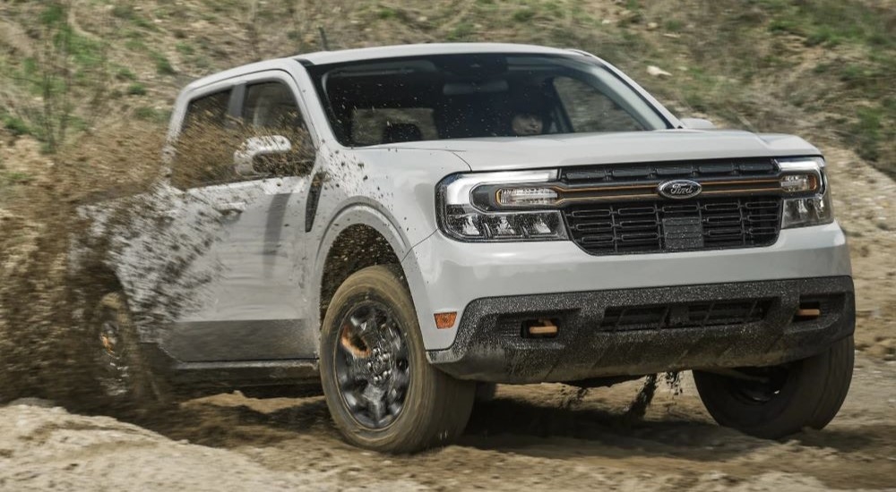 A grey 2024 Ford Maverick Tremor is shown kicking up dirt after leaving an Oakland Ford dealer.