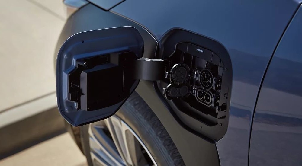 A close up shows the open charging port on a blue 2023 Subaru Solterra for sale.