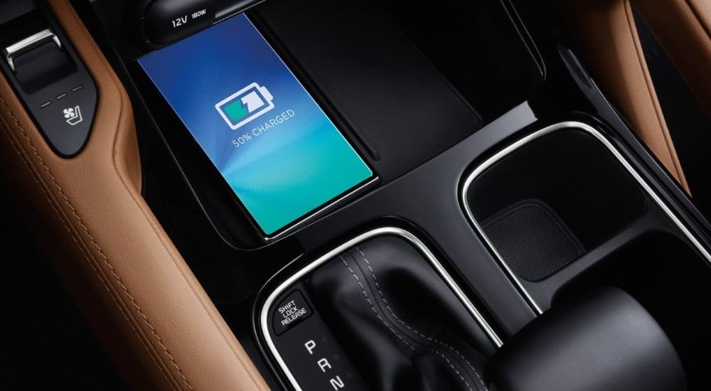 A close up of a cellphone charging in the center console of a 2024 Kia Telluride.