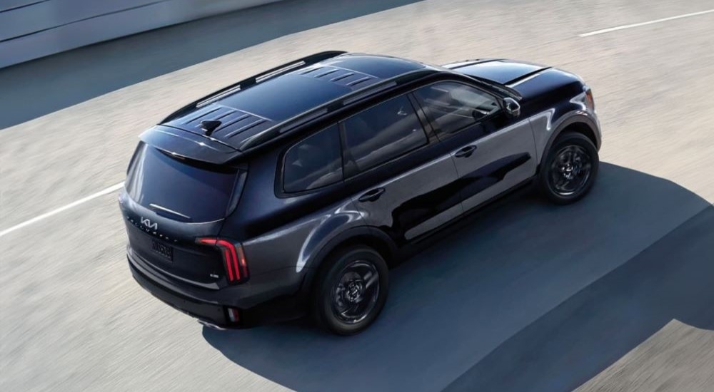 Overhead view of a black 2024 Kia Telluride driving on the highway after leaving a Kia dealer near me.