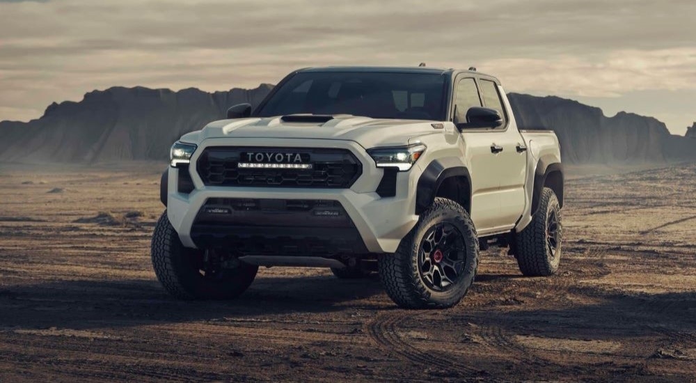 A white 2024 Toyota Tacoma TRD Pro is shown parked off-road.