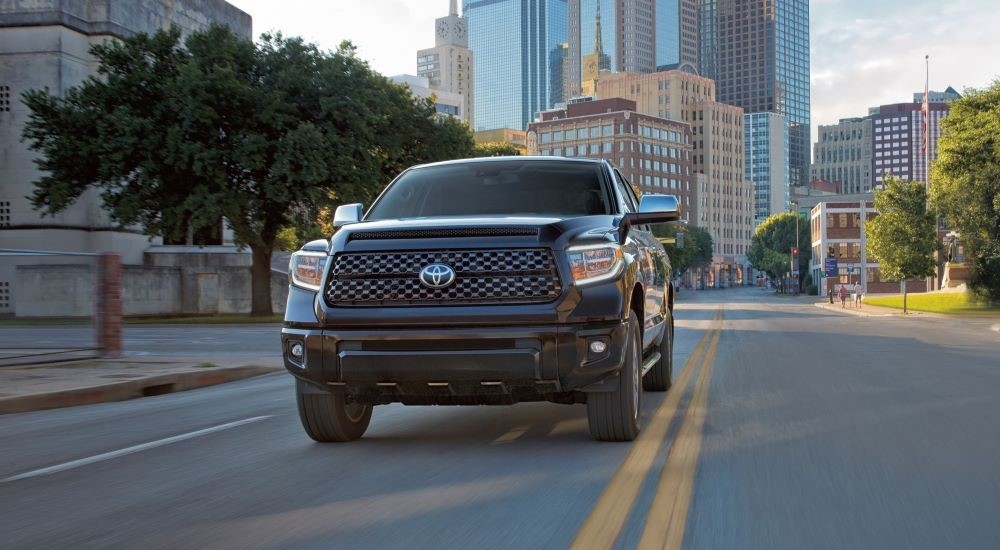 A black 2021 Toyota Tundra is shown driving on a city street.