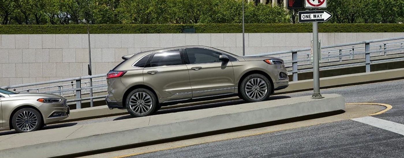 One of the most popular Ford SUVs, a gold 2020 Ford Edge, is shown from the side on a city street.