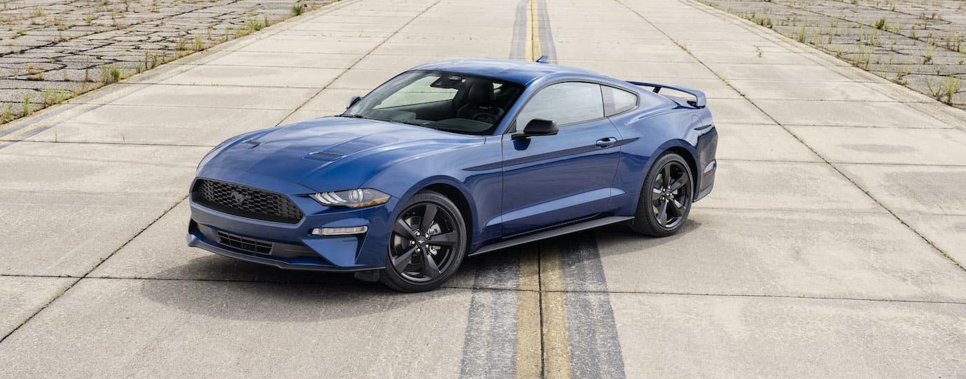 A blue 2022 Ford Mustang Stealth Edition is shown from a high angle parked on a concrete runway.