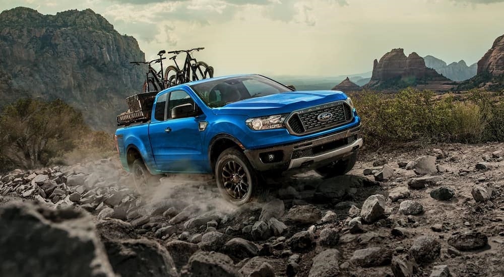 A blue 2022 Ford Ranger FX4 is shown driving up a rocky trail after visiting a Ford dealer near you.