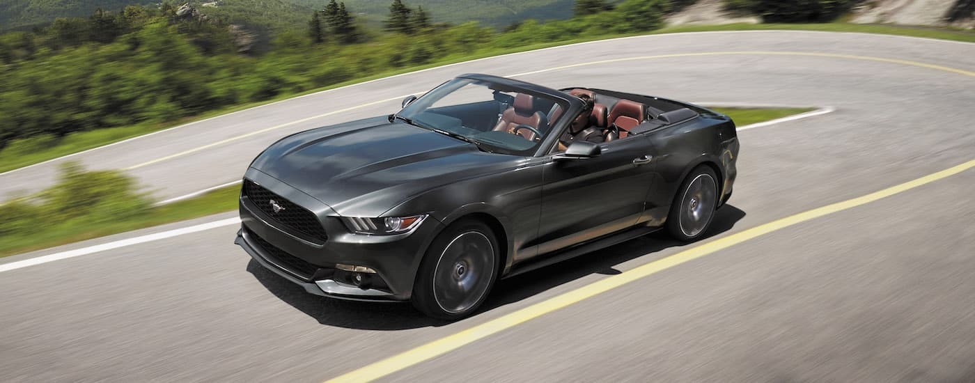A grey 2017 Ford Mustang is shown rounding a corner after visiting a used Ford dealership.