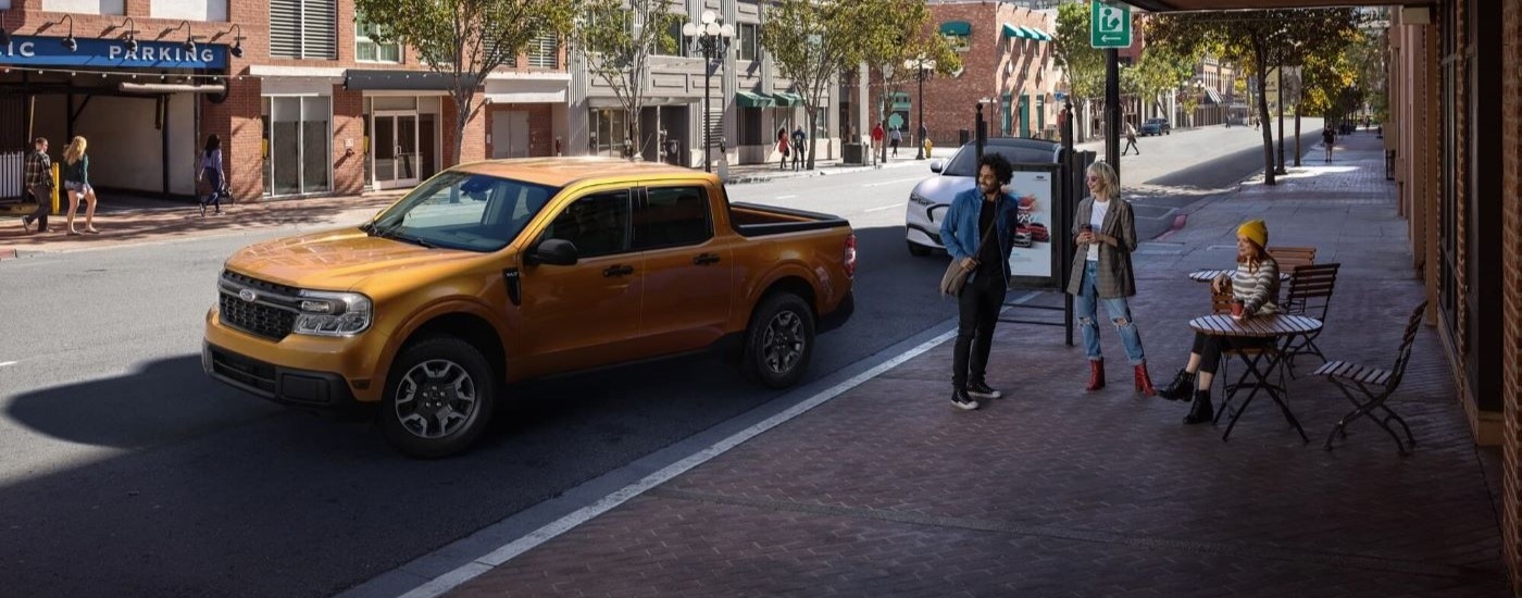 A gold 2022 Ford Maverick is shown parked on the side of a city street.