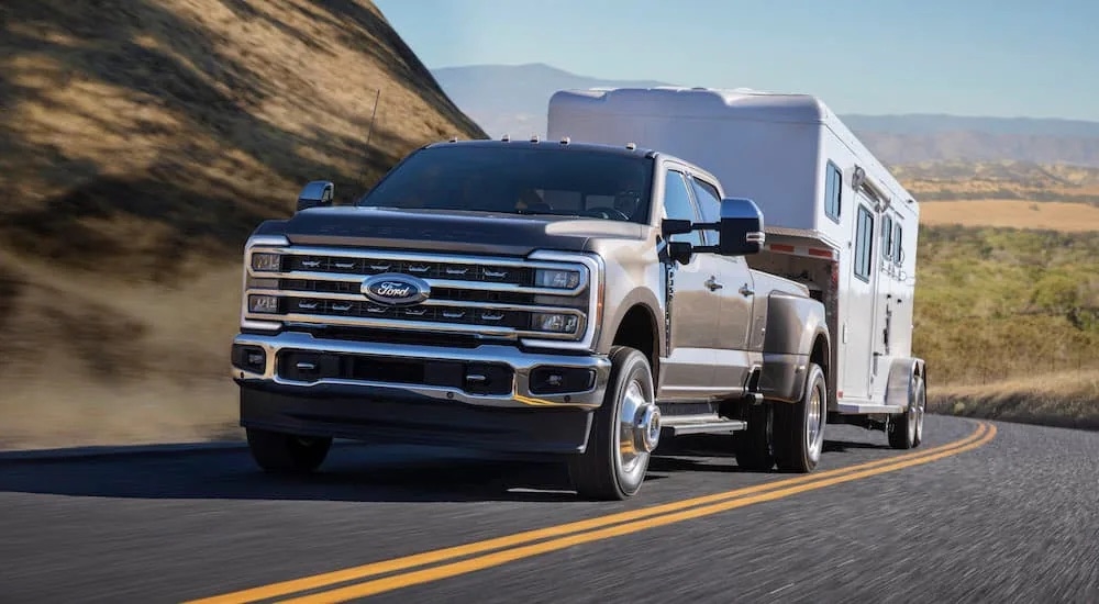 A grey 2023 Ford F-350 is shown front while towing a trailer.