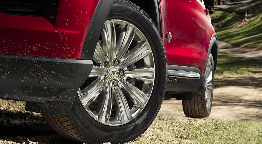 A close up shows the silver rim on a red 2023 Ford Explorer King Ranch.