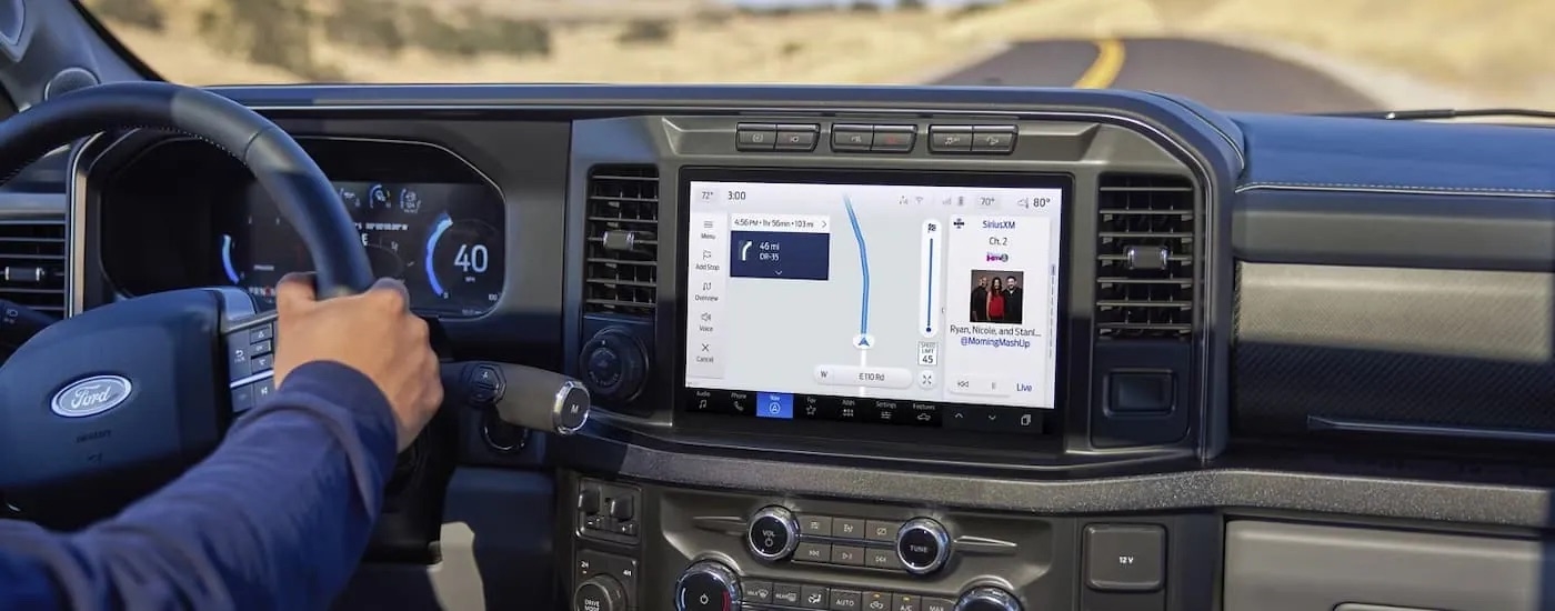 A person is shown driving a 2023 Ford F-250 for sale during a test drive.