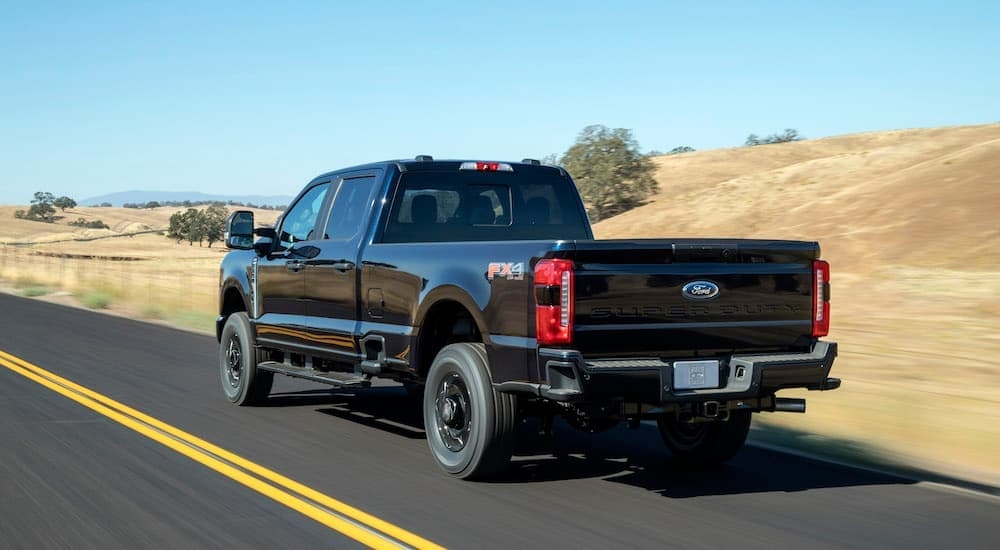 A black 2023 Ford F-250 is shown from the rear at an angle.