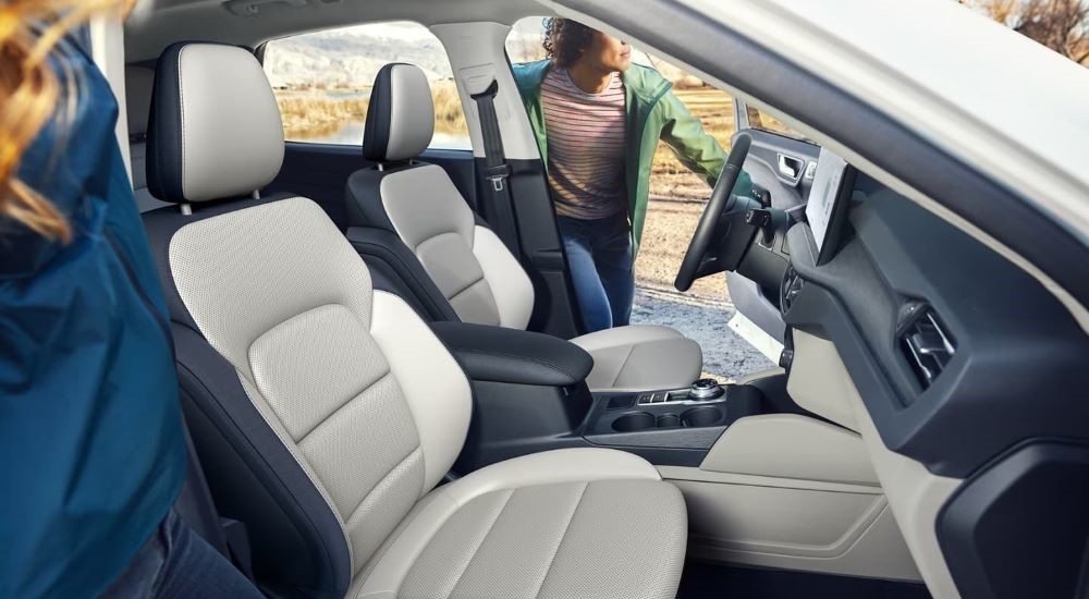 The grey and black interior of a 2023 Ford Escape for sale shows the the front seating.