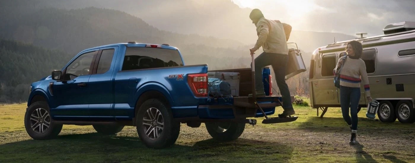 A blue 2022 Ford F-150 STX is shown at a campsite.